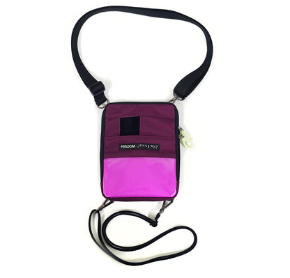 A Suare zippered pouch with a 3 x 5 clear plastic window on the lower half. The bright lining shows through when no badge is placed in the window.  There is a small square opening at the top to place the camera. Wide neck strap and thinner waist strap, and a Feeldom braille label runs across the middle.